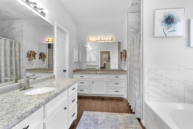 bathroom featuring separate shower and tub and vanity