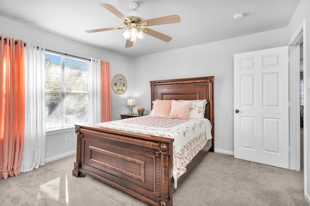 bedroom with light colored carpet, ceiling fan, and multiple windows