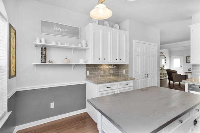 kitchen featuring white cabinetry, decorative light fixtures, stainless steel dishwasher, and decorative backsplash