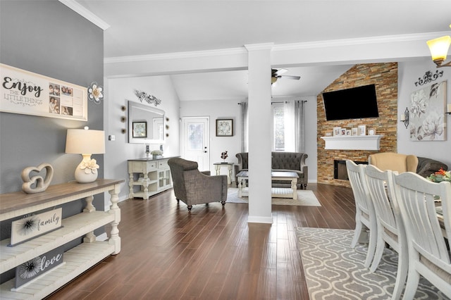 living room featuring vaulted ceiling, crown molding, dark hardwood / wood-style flooring, a fireplace, and ceiling fan