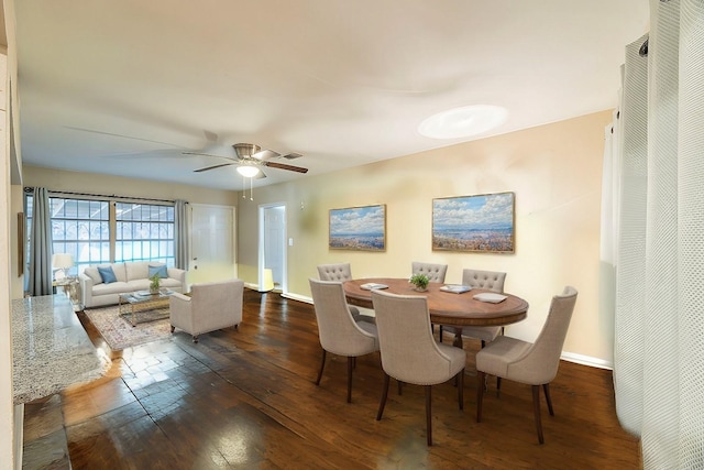 dining space with ceiling fan and dark hardwood / wood-style flooring