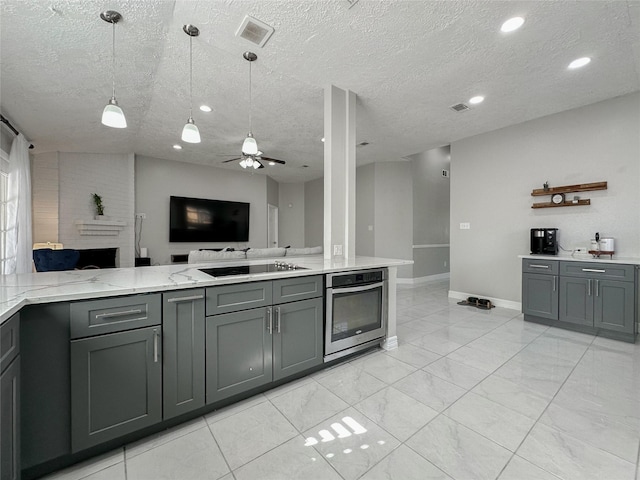 kitchen featuring oven, decorative light fixtures, and gray cabinetry