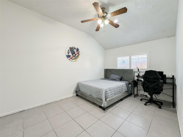 tiled bedroom featuring a textured ceiling, ceiling fan, and vaulted ceiling