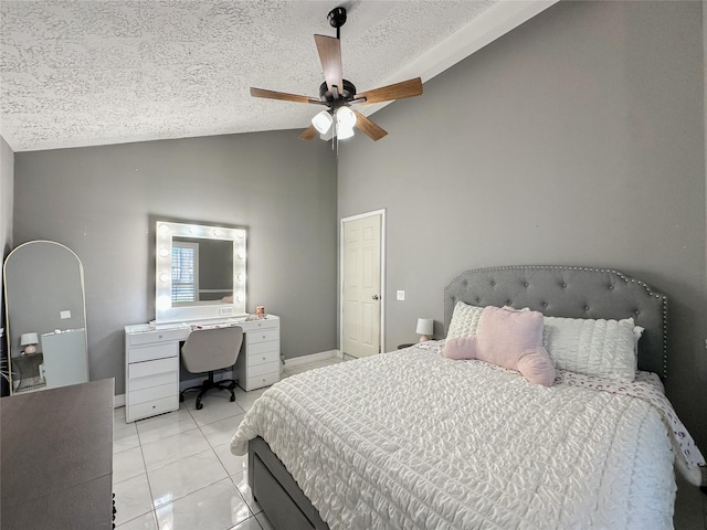 bedroom with lofted ceiling, a textured ceiling, ceiling fan, and light tile patterned floors