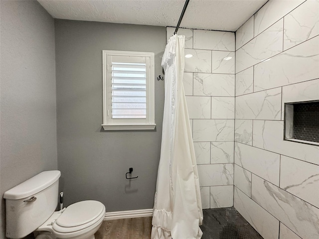 bathroom featuring a shower with curtain, hardwood / wood-style flooring, a textured ceiling, and toilet