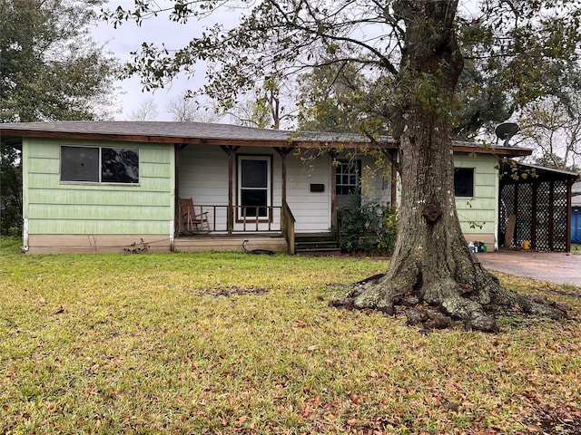 ranch-style house with a carport, a front yard, and covered porch