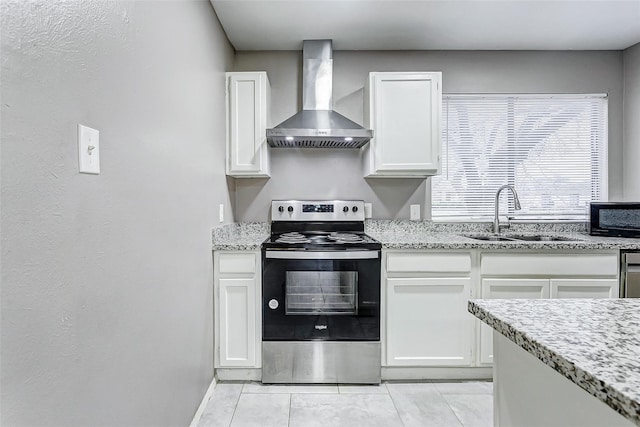 kitchen featuring white cabinets, electric stove, light tile patterned floors, wall chimney exhaust hood, and sink