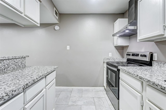 kitchen with white cabinets, electric range, wall chimney range hood, and light stone countertops