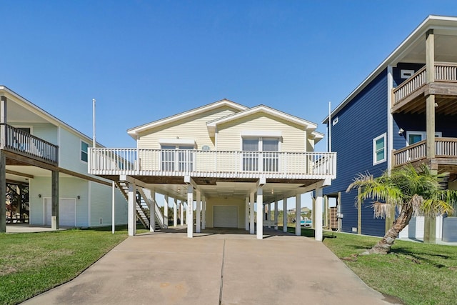 coastal inspired home featuring a front yard and a carport