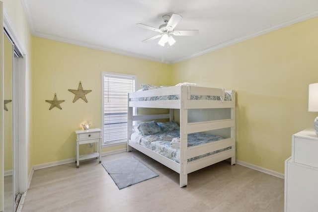 bedroom with a closet, ceiling fan, crown molding, and light hardwood / wood-style floors