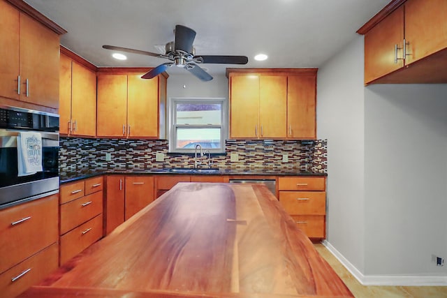 kitchen with appliances with stainless steel finishes, sink, ceiling fan, and wood counters