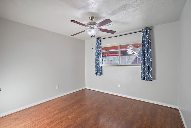 empty room with a textured ceiling, ceiling fan, and hardwood / wood-style floors