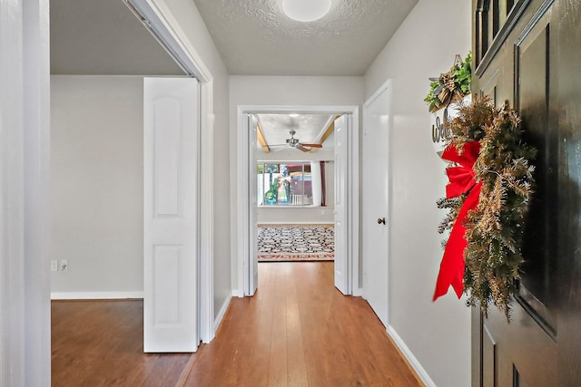 hall featuring a textured ceiling and dark wood-type flooring