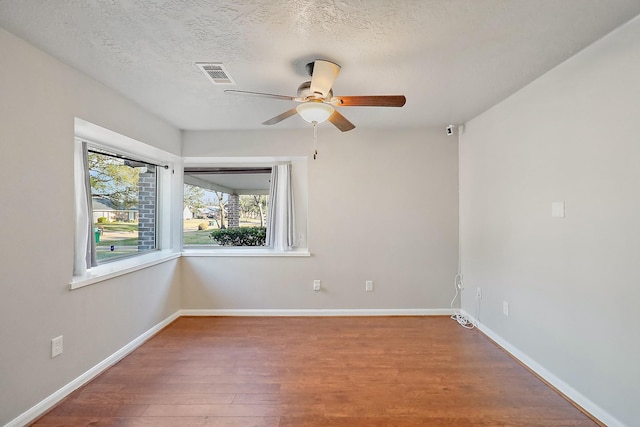 spare room with a textured ceiling, ceiling fan, and hardwood / wood-style floors