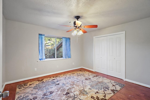 bedroom featuring ceiling fan, a closet, a textured ceiling, and wood-type flooring