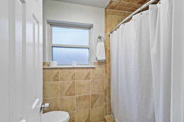 bathroom featuring toilet, tile walls, and a shower with curtain