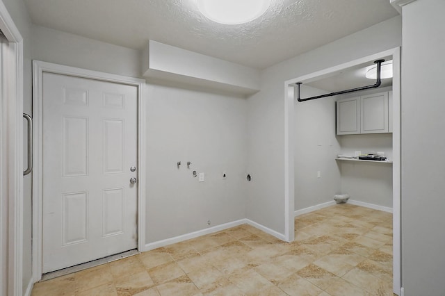 laundry room featuring a textured ceiling and cabinets