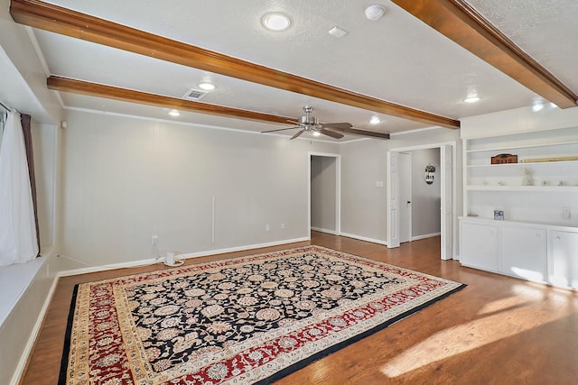 interior space with beamed ceiling, hardwood / wood-style floors, ceiling fan, and built in features