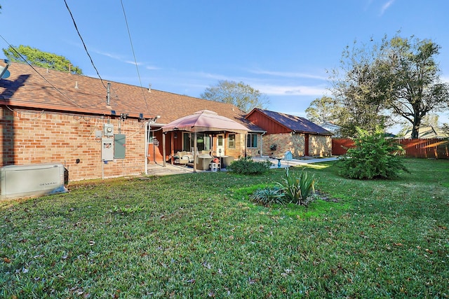 rear view of house with a gazebo, a patio, and a yard