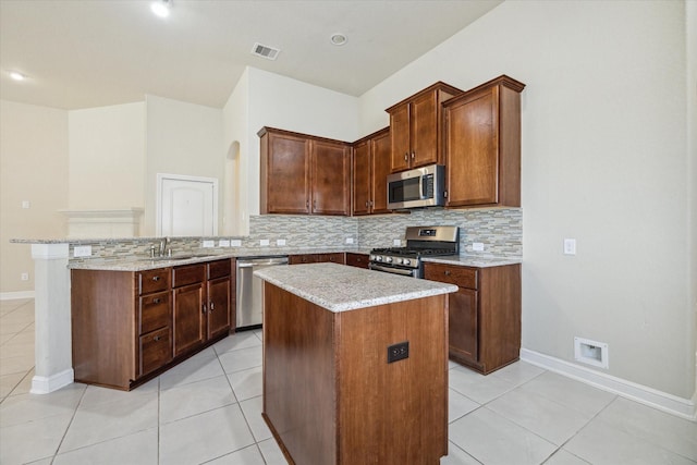 kitchen with appliances with stainless steel finishes, kitchen peninsula, a center island, and sink