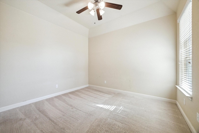 carpeted spare room featuring ceiling fan and vaulted ceiling