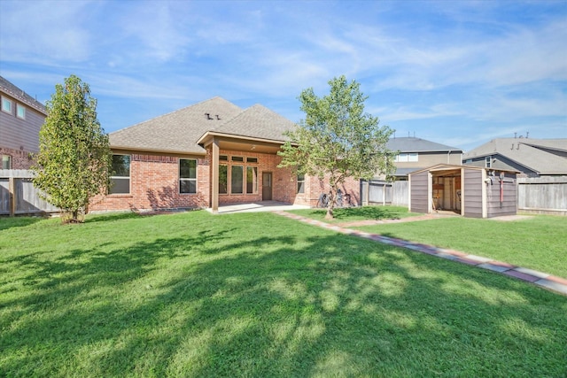 rear view of property with a lawn, a patio area, and a storage unit