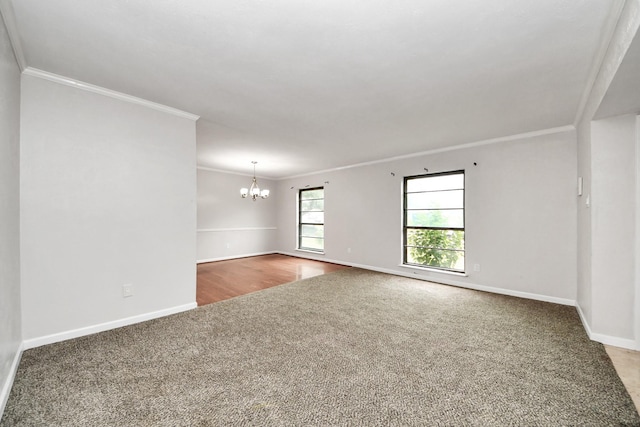 carpeted spare room with crown molding and a chandelier