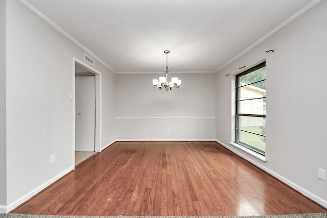 unfurnished room with ornamental molding, hardwood / wood-style floors, a wealth of natural light, and a chandelier