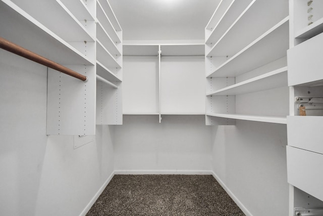 spacious closet featuring dark carpet