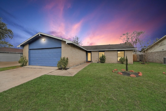 single story home with central AC unit, a garage, and a lawn