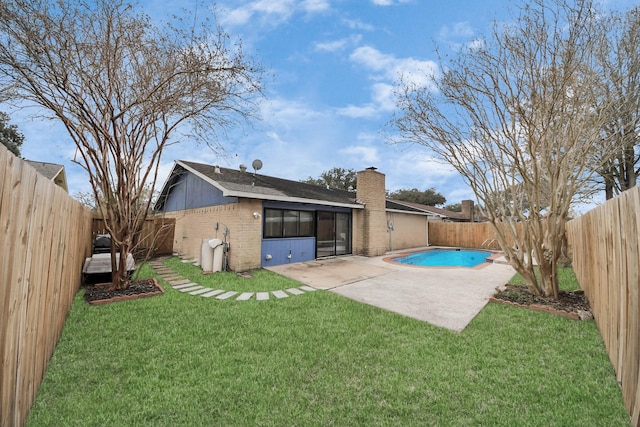 back of property with a lawn, a fenced in pool, and a patio