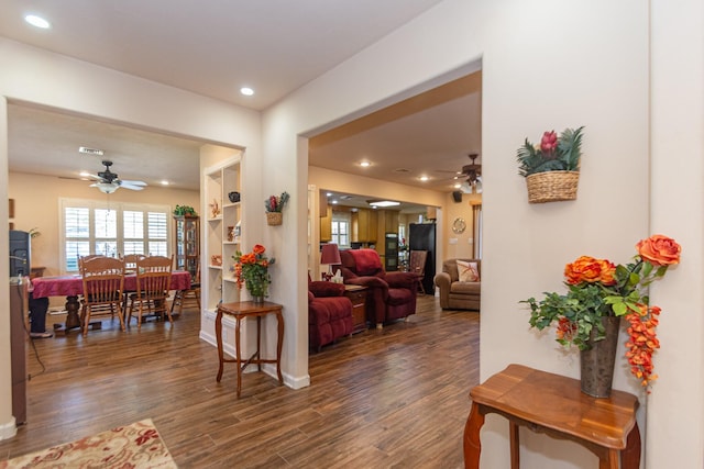 living room featuring ceiling fan and dark wood-type flooring