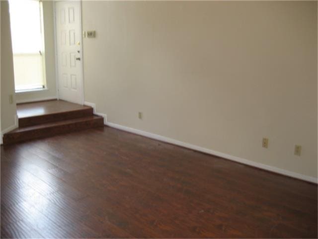 empty room with dark wood-type flooring