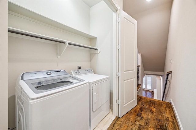 washroom with washing machine and dryer and wood-type flooring