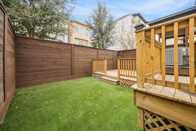 view of yard with a wooden deck and central air condition unit