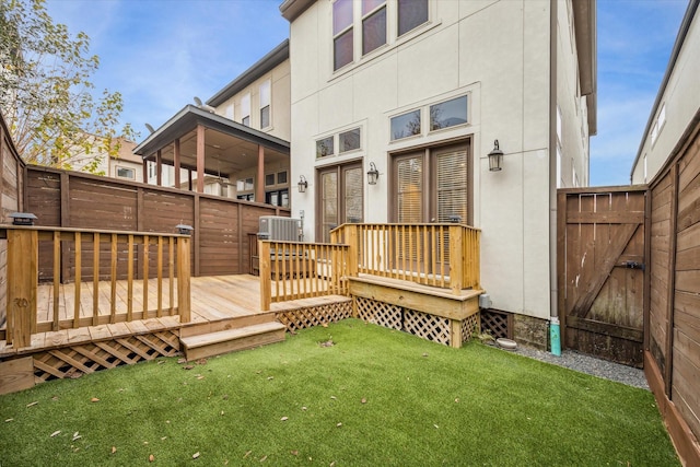 back of property with central air condition unit, a deck, and a yard