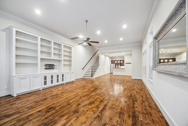 unfurnished living room with ceiling fan, crown molding, and wood-type flooring