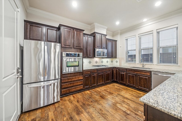 kitchen featuring sink, stainless steel appliances, decorative backsplash, and light stone countertops