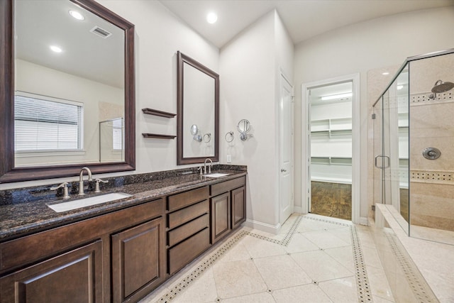 bathroom featuring a shower with door, vanity, and tile patterned floors