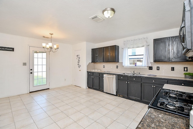 kitchen featuring a chandelier, light tile patterned floors, backsplash, appliances with stainless steel finishes, and sink