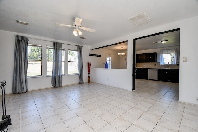 tiled empty room featuring ceiling fan with notable chandelier