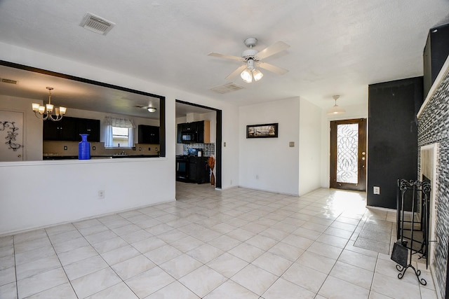 unfurnished living room with ceiling fan with notable chandelier and light tile patterned floors