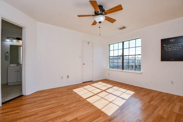 unfurnished bedroom featuring ensuite bathroom, ceiling fan, and light hardwood / wood-style flooring