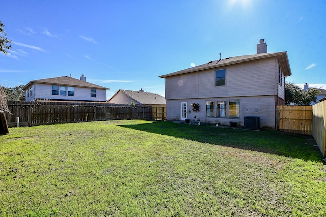 back of house featuring cooling unit and a lawn