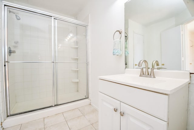 bathroom with tile patterned floors, walk in shower, and vanity