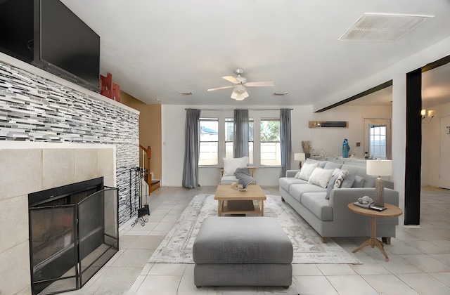 tiled living room featuring a tile fireplace and ceiling fan