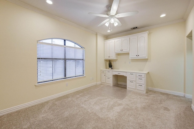 unfurnished office featuring ceiling fan, ornamental molding, and light carpet