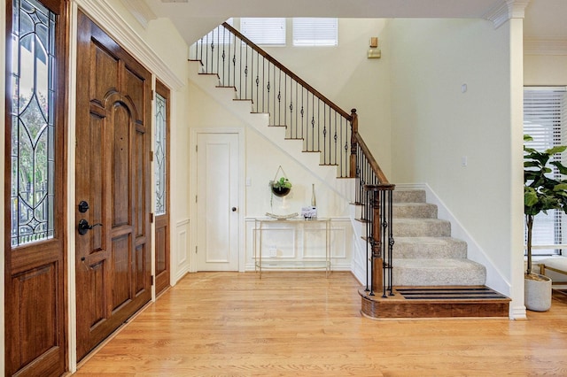 foyer featuring light wood-type flooring and ornamental molding