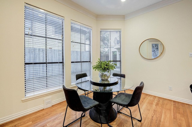 dining space featuring light hardwood / wood-style floors and crown molding