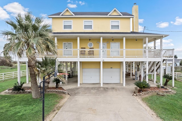 view of front of property with a porch, a front lawn, and a garage